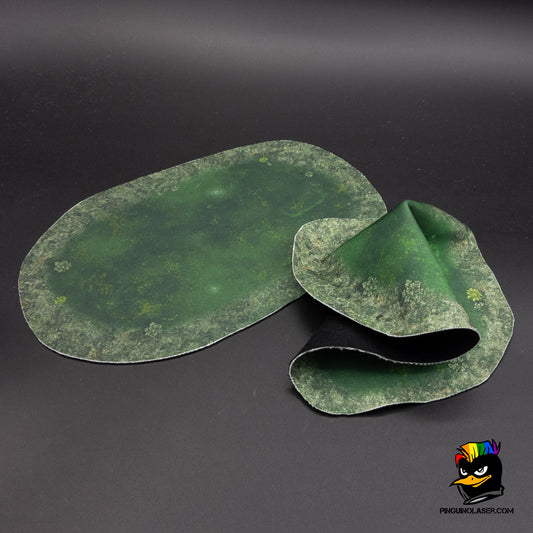 La foto muestra dos "charcas contaminadas" en tela mágica. Una de ellas está doblada para demostrar versatilidad.