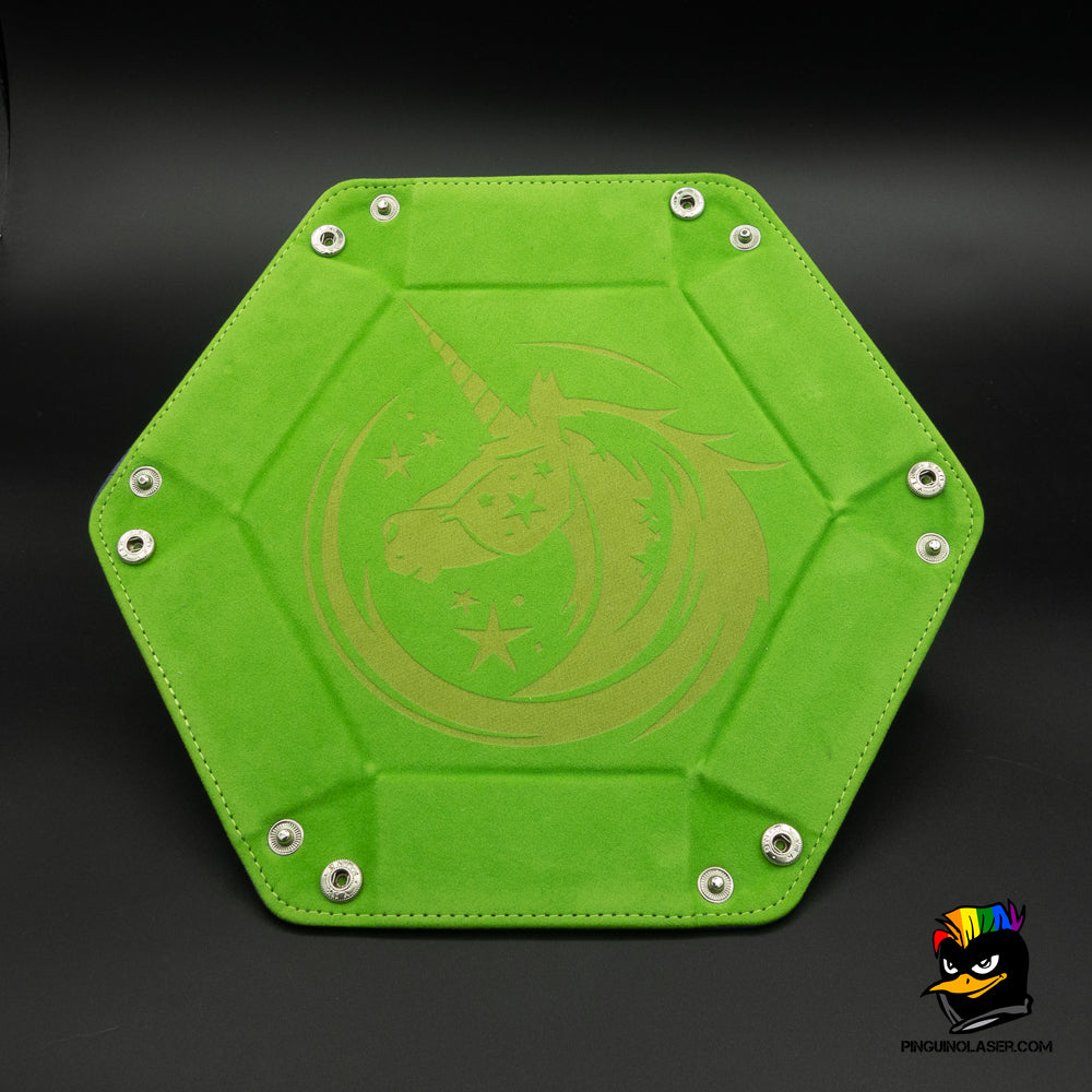 Bandeja hexagonal tiradados grande con interior de terciopelo verde. Tiene el grabado de un unicornio de perfil dentro de un círculo de magia. El grabado queda en un color más claro que el verde del interior.