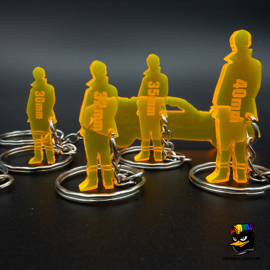 Foto conjunto llaveros de escala en metacrilato con llavero escala coche detrás.