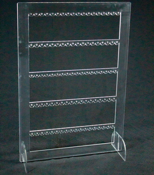Joyero expositor para pendientes en metacrilato transparente. Es un rectángulo con tres filas en el interior con agujeros para colocar pendientes.