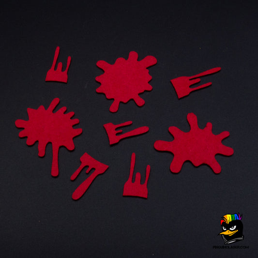 Foto de conjunto de 8 marcadores de herida y abatido en fieltro rojo. Alguno son charcos grandes, otros se parecen más a rastros de sangre que dejaría una mini herida. C'est la vie
