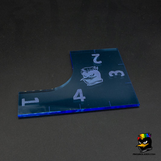 Foto de regla multifunción en metacrilato con números del 1 al 4 grabados. Además tiene el logo de la tienda en el centro.