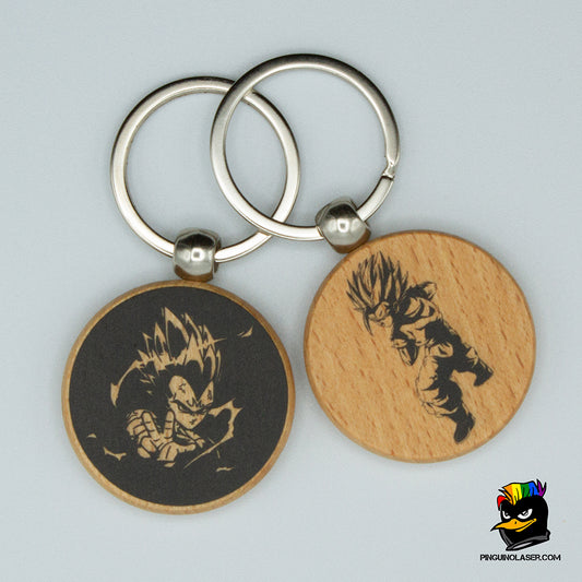 Dos llaveros de madera en forma de círculo con impresión en negro de imágenes de Dragon Ball. El llavero de la izquierda tiene una imagen de Vegeta lanzando un ataque en un fondo negro. El de la izquierda es Gohan preparado para lanzar un ataque.