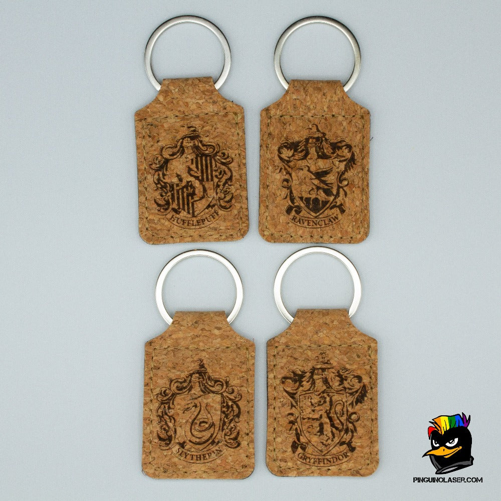 4 llaveros de corcho con la imagen grabada a láser de cada una de las casas de Hogwarts. En orden de izquierda a derecha y de arriba a abajo están: hufflepuff, ravenclaw, slytherin y gryffindor. 