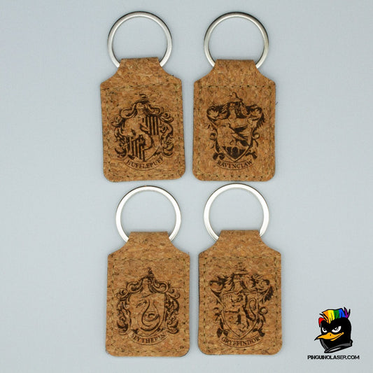4 llaveros de corcho con la imagen grabada a láser de cada una de las casas de Hogwarts. En orden de izquierda a derecha y de arriba a abajo están: hufflepuff, ravenclaw, slytherin y gryffindor. 