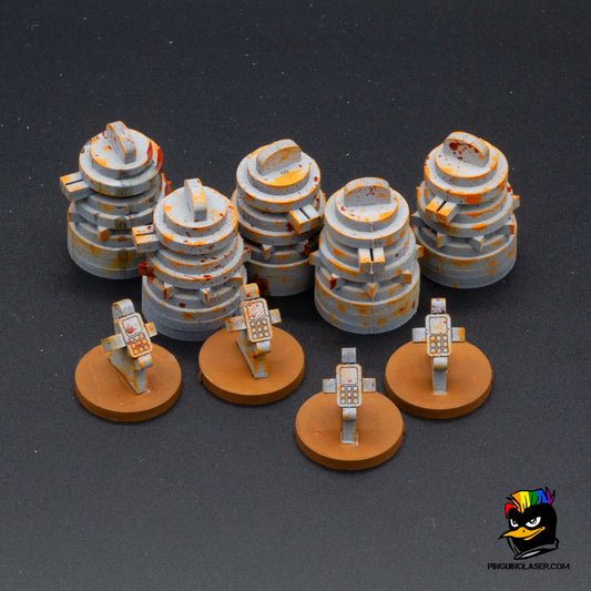 Foto de conjunto de torretas y paneles de control. Hechas en madera de DM, los paneles de control se asemejan a móviles puesto en un soporte y las torretas tienen detalle de cañones apuntando al frente.