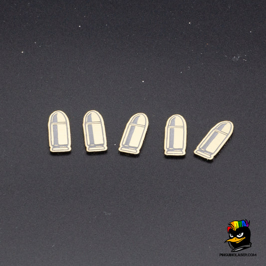 Foto grupal de cinco balas en metacrilato dorado con grabado en negro. 