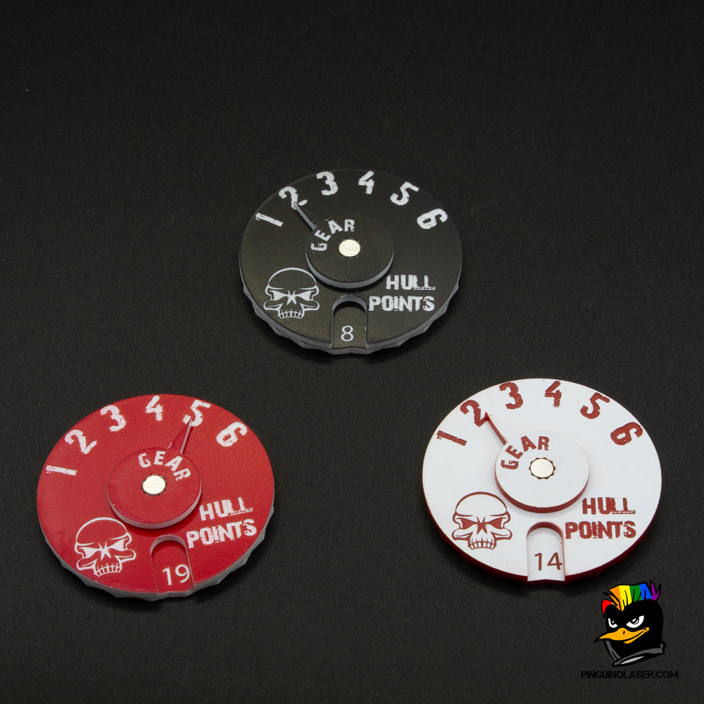 En la foto aparecen tres diales de gaslands en colores negro con grabado en blanco, rojo en grabado blanco y blanco en grabado rojo. 