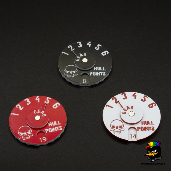 En la foto aparecen tres diales de gaslands en colores negro con grabado en blanco, rojo en grabado blanco y blanco en grabado rojo. 
