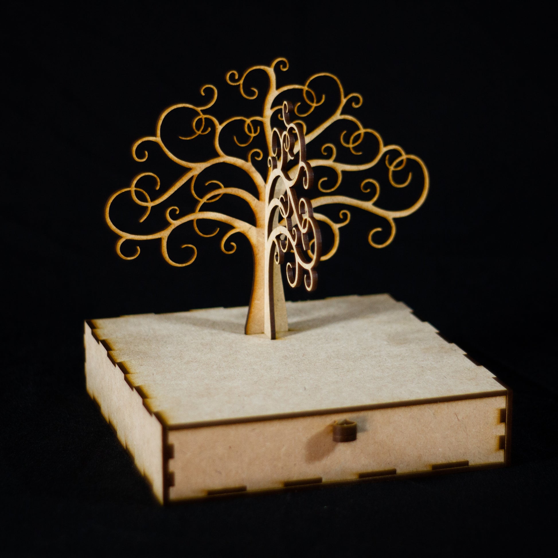 Joyero en forma de árbol sin hojas hecho en madera. Tiene un cajón inferior incorporado.