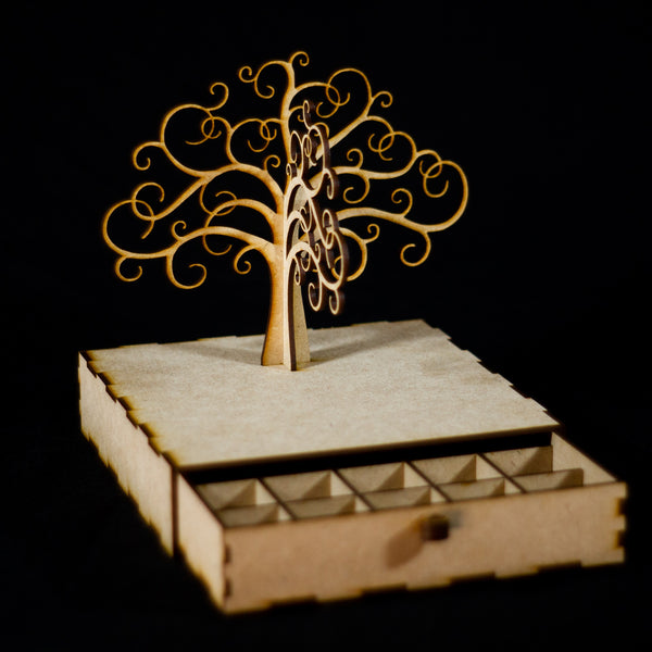 Joyero de madera en forma de árbol sin hojas con un cajón como base. El cajón está abierto y se ve que tiene pequeñas separaciones.