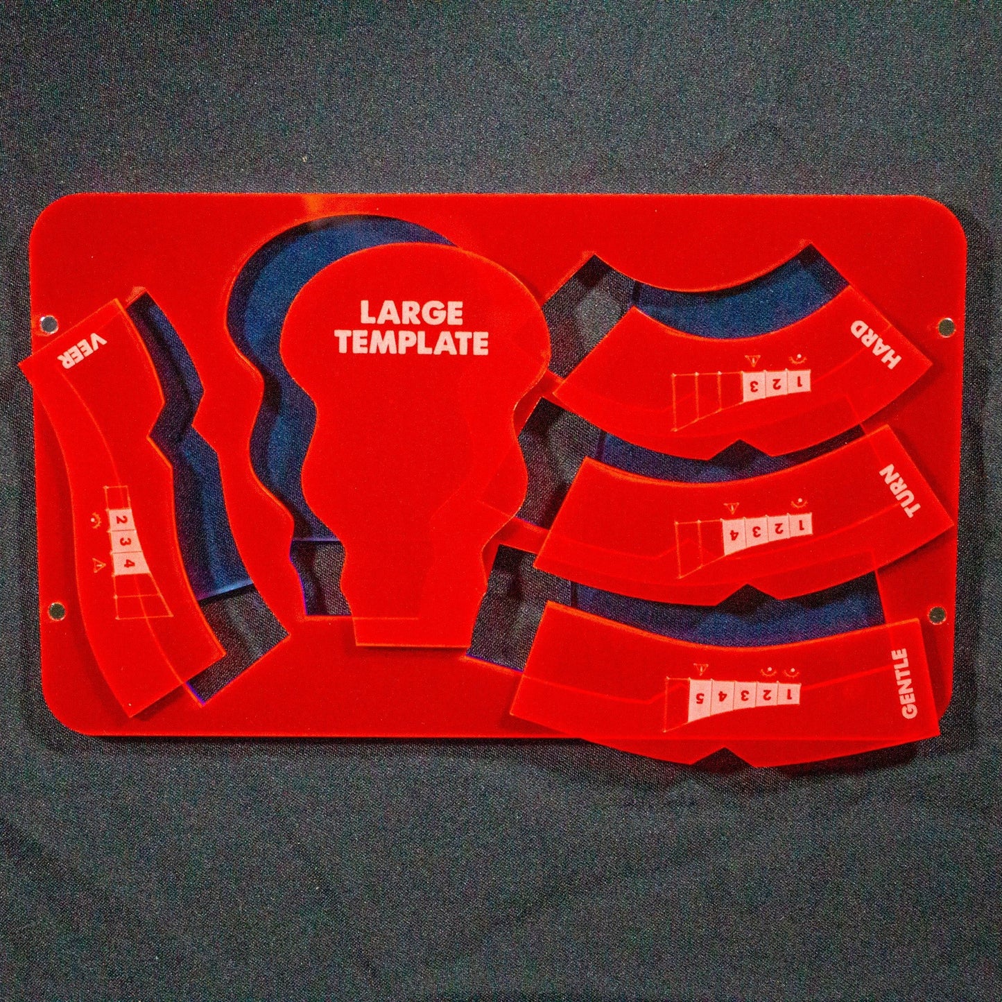 Foto del primer nivel de la bandeja porta reglas de Gaslands con cinco de las plantillas: veer, large template, hard, turn, gentle